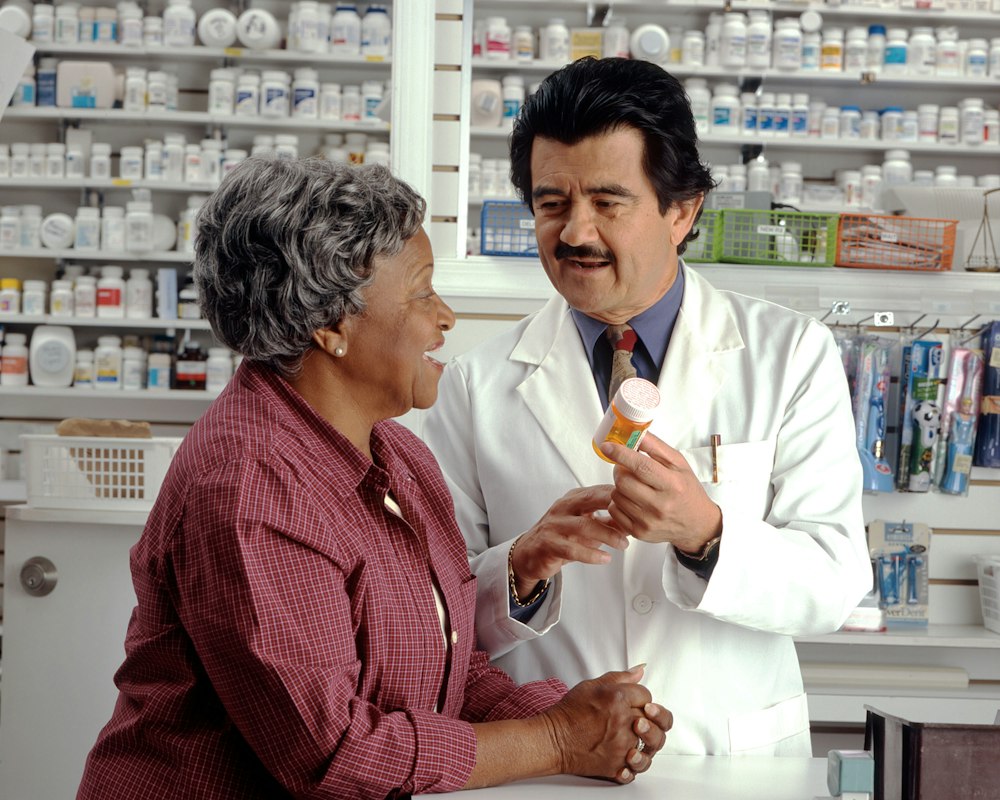Pharmacien et cliente au comptoir de la pharmacie